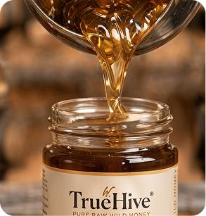 Pure honey being poured into a TrueHive jar